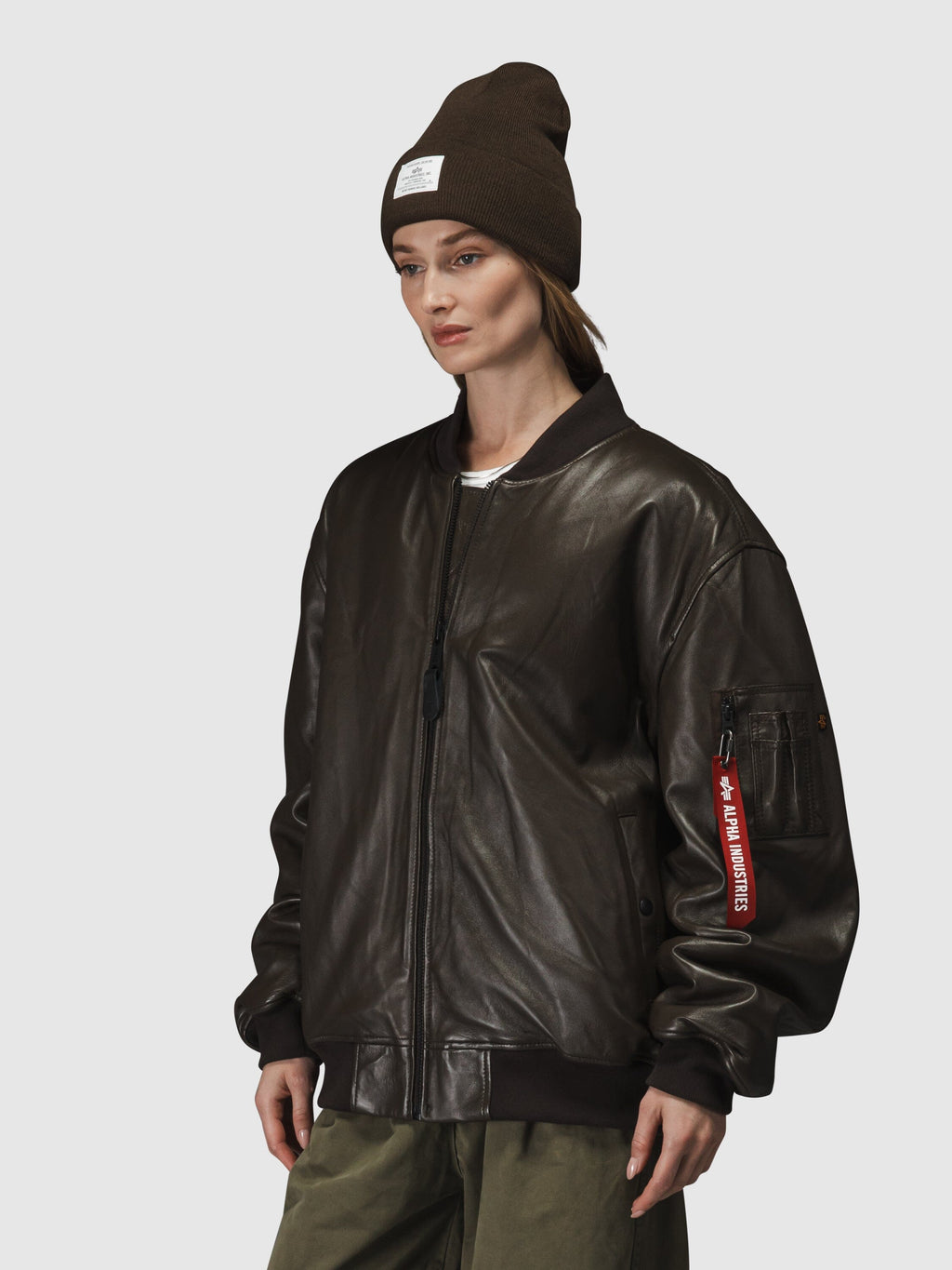 Alpha Industries Leather MA-1 Flight Jacket in brown, with olive pants and brown beanie.