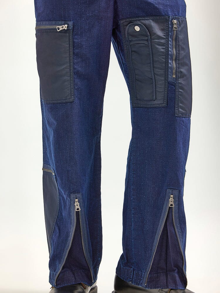 The Alpha X Lee Flight Suit by Alpha Industries, crafted from durable ripstop cotton, boasts multiple pockets and zippered sections on the legs, perfectly blending fashion performance with utility.