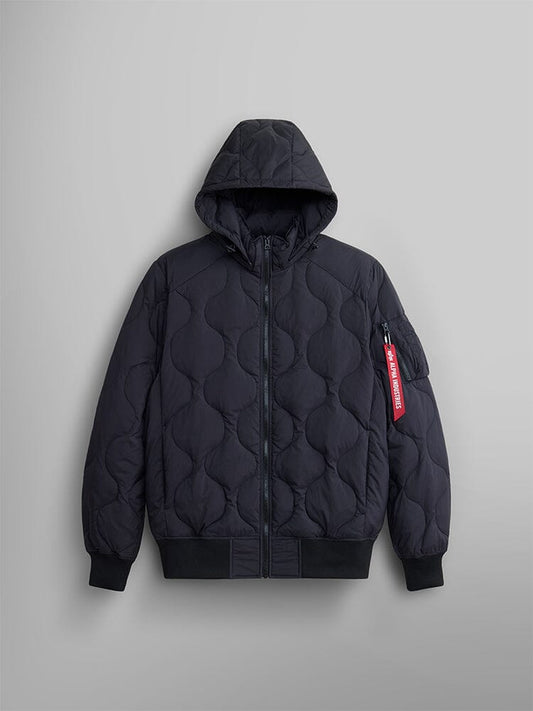 The Lightweight Quilted Down Jacket by Alpha Industries features a black design with down filling, removable hood, ribbed cuffs, front zipper, and a distinctive red Alpha Industries tag on the sleeve.