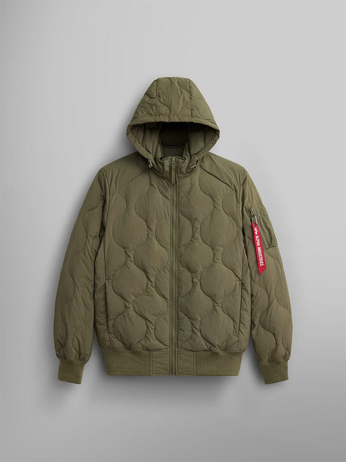 The lightweight quilted down jacket in OG-107 green from Alpha Industries, featuring a removable hood, a zipper closure, and a red tag on the sleeve.