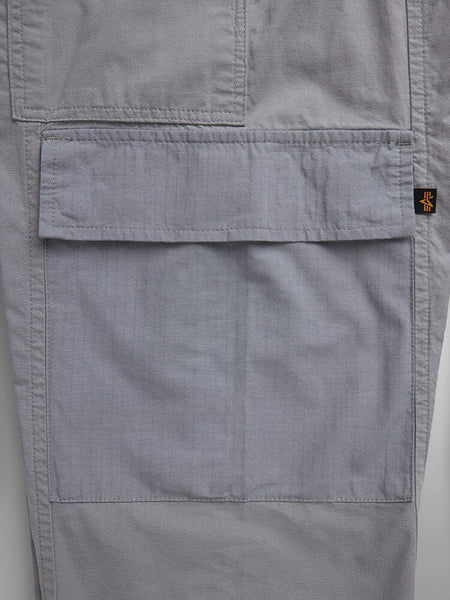 Lightweight Trouser W by Alpha Industries, gray, garment-washed cotton, cargo pocket with flap and visible stitching, small black and yellow tag.