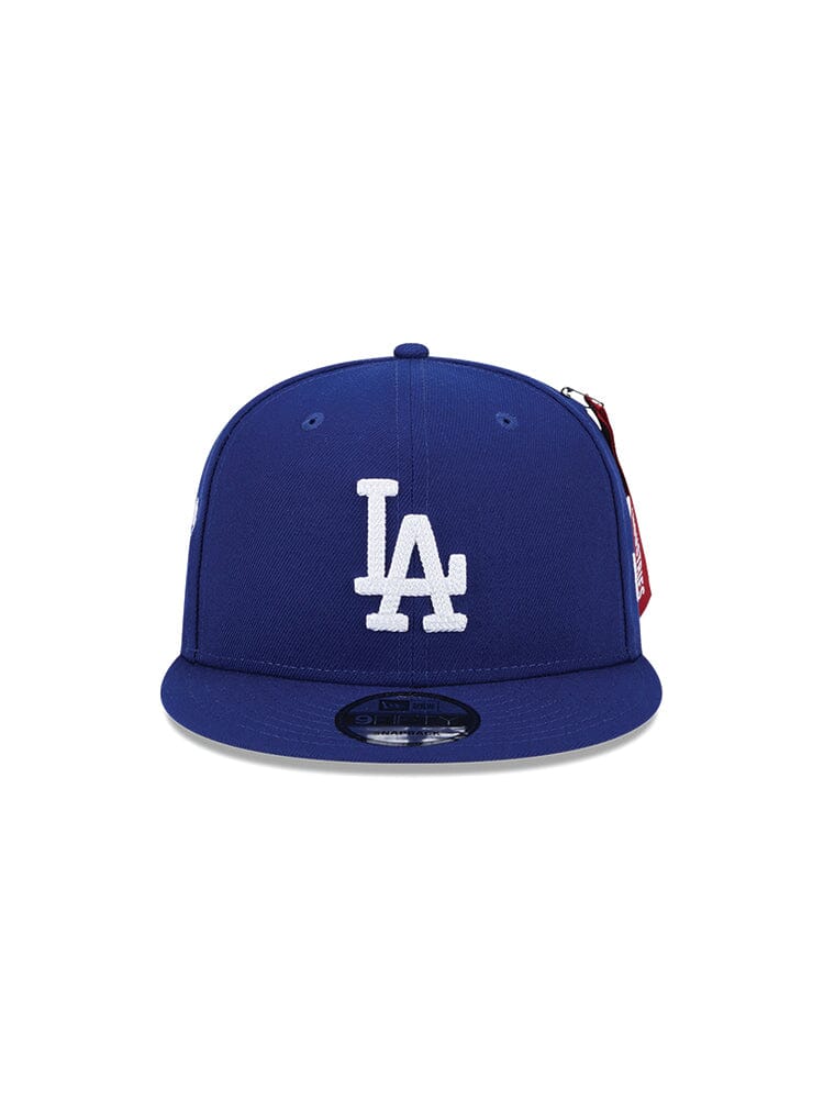 The Los Angeles Dodgers x Alpha x New Era 950 Cap (Blue) showcases a white LA team logo on the front and is crafted in collaboration with Alpha Industries and New Era.