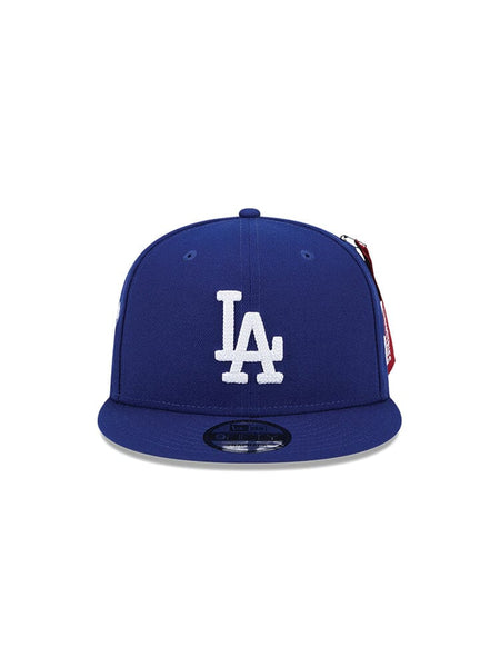 The Los Angeles Dodgers x Alpha x New Era 950 Cap (Blue) showcases a white LA team logo on the front and is crafted in collaboration with Alpha Industries and New Era.