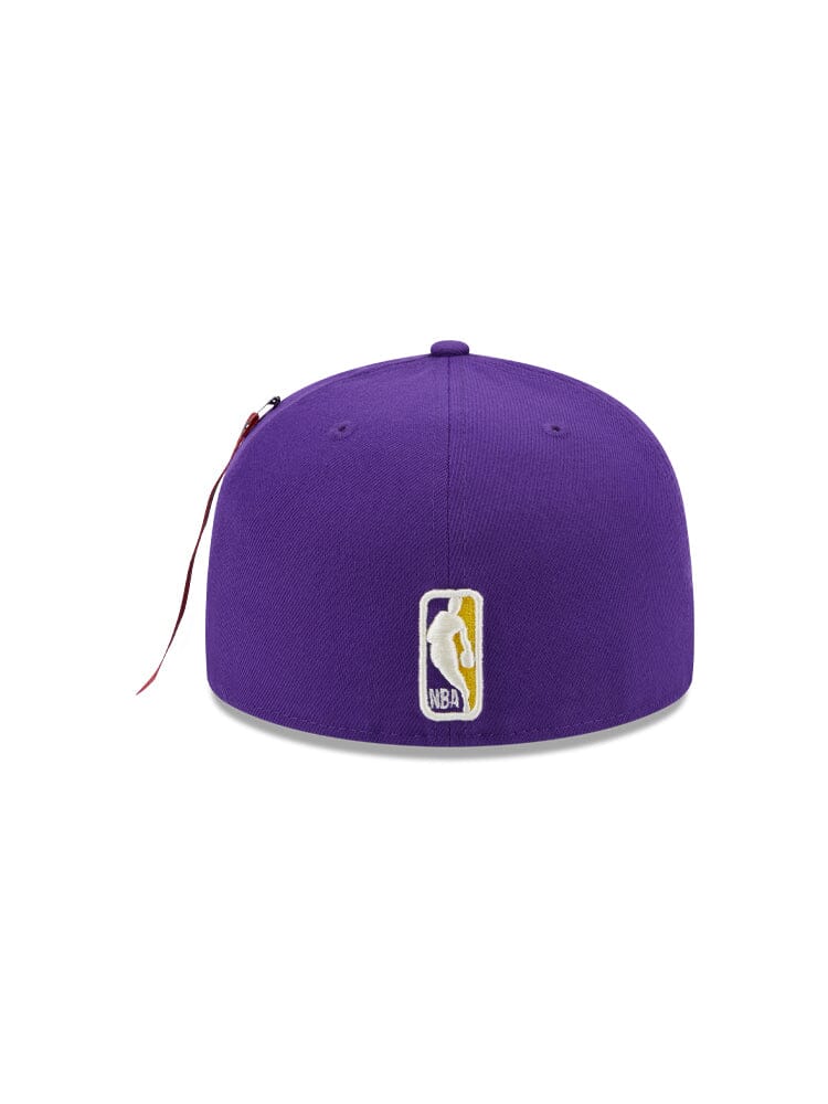 This Los Angeles Lakers x Alpha Industries x New Era 59FIFTY Fitted Cap, in purple, showcases the iconic NBA team logo on the back. This design from Alpha Industries and NE-NBA provides a sleek and stylish look, ideal for sports enthusiasts.