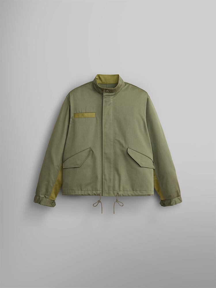 The M-65 Long Liner in OG-107 Green by Alpha Industries. This jacket boasts a stand-up collar, front pocket, and adjustable cuffs.