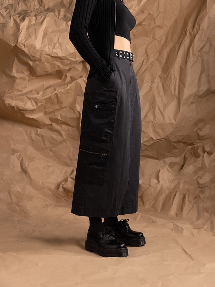 A person dressed in the Women's M-65 Skirt in black by Alpha Industries, paired with a black crop top and platform shoes.