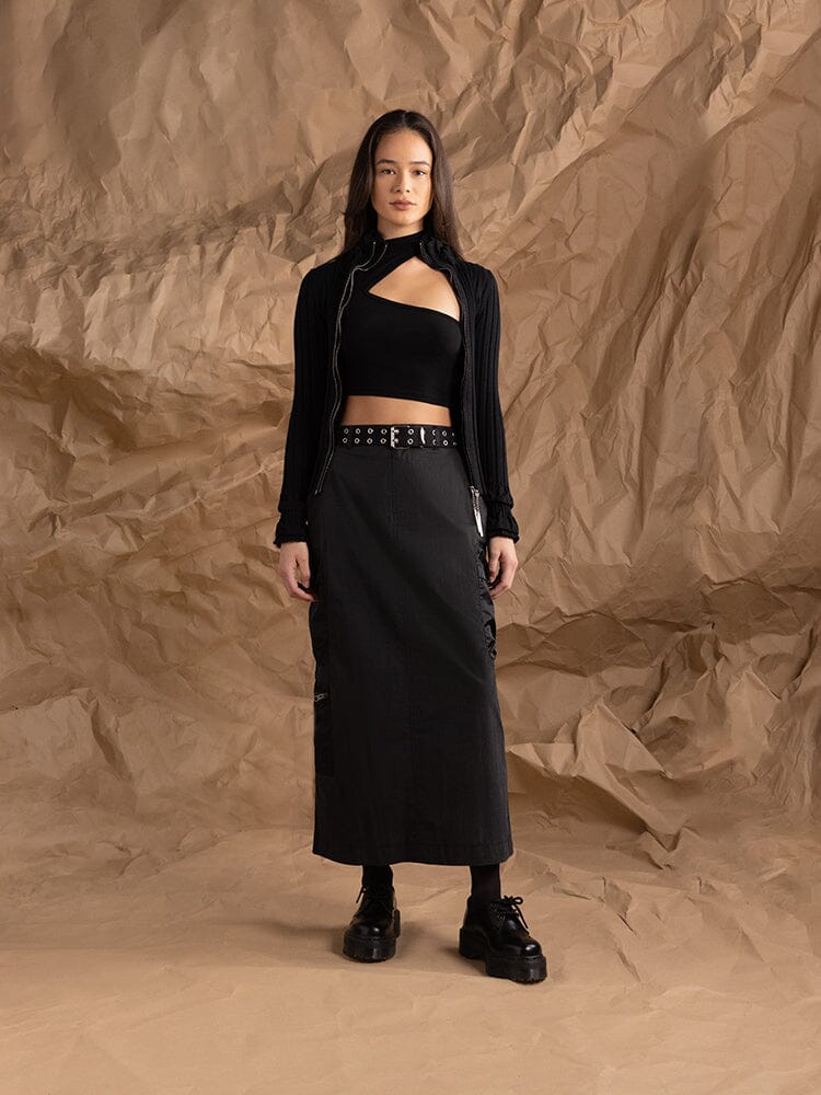 A woman poses dressed in a black ensemble that includes the Alpha Industries Women's M-65 Skirt with an adjustable waistband and a cut-out top.