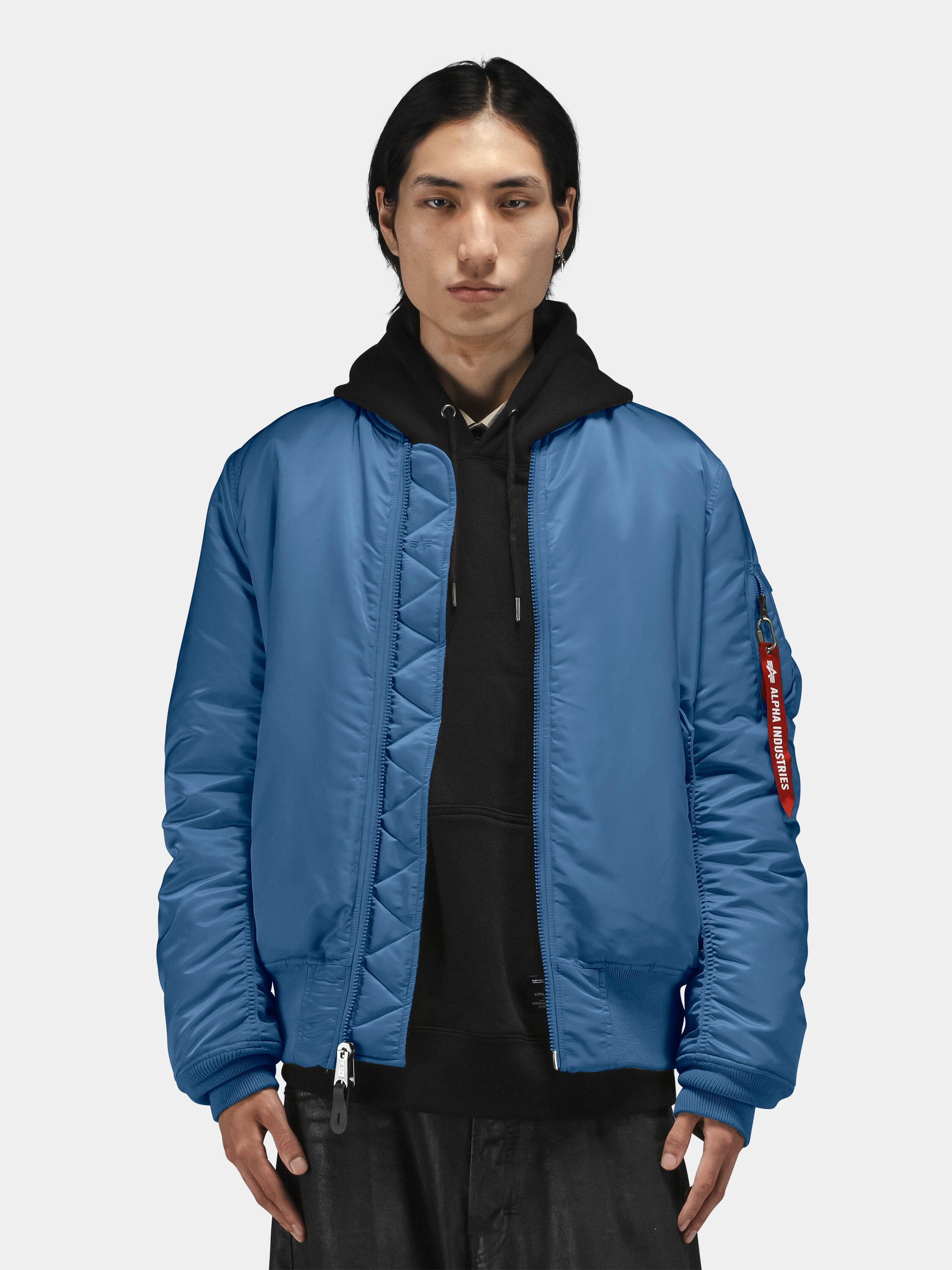 Alpha Industries MA-1 bomber jacket in blue, layered over a black hoodie.