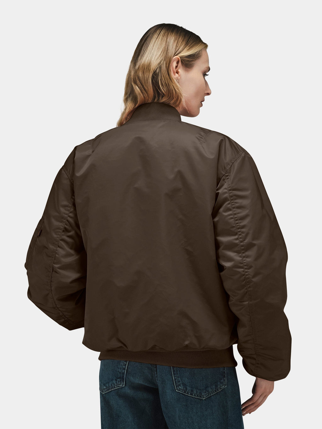 Alpha Industries MA-1 Bomber Jacket in brown with blue jeans.