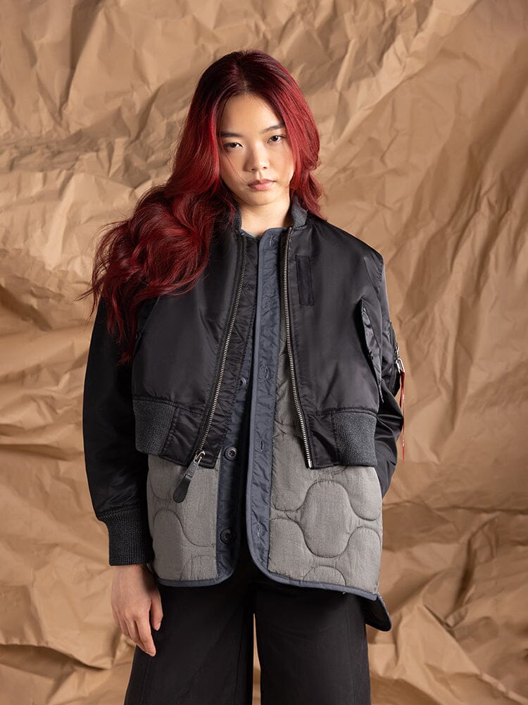 A person models the Women's 3-in-1 MA-1 Quilted Liner by Alpha Industries, showcasing a cropped outer jacket layered over an onion quilted liner.