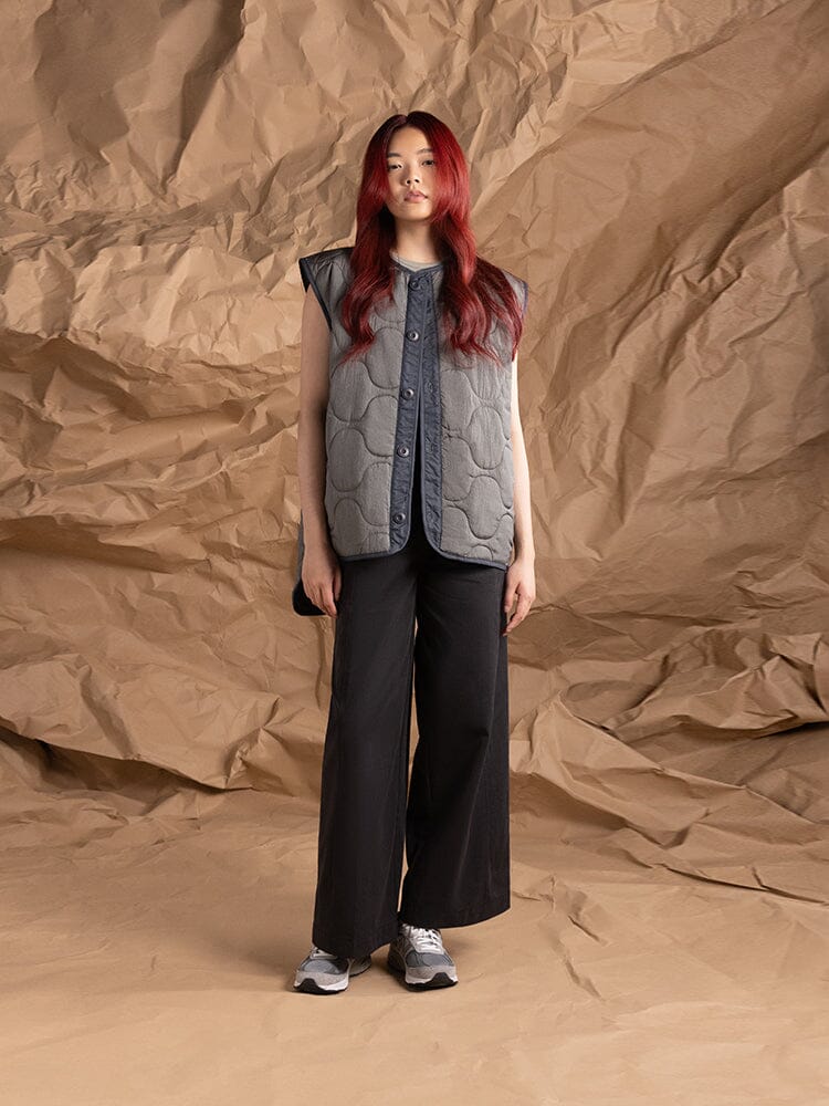 A person dressed in an Women's 3-in-1 MA-1 Quilted Liner by Alpha Industries. without sleeves, showcasing the quilted liner.