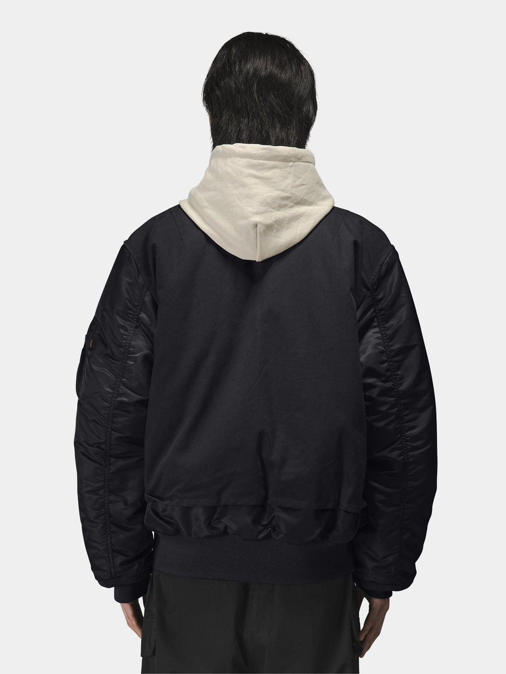 Alpha Industries MA-1 Mixed Cotton Flight Jacket in black, layered over light-colored hoodie.