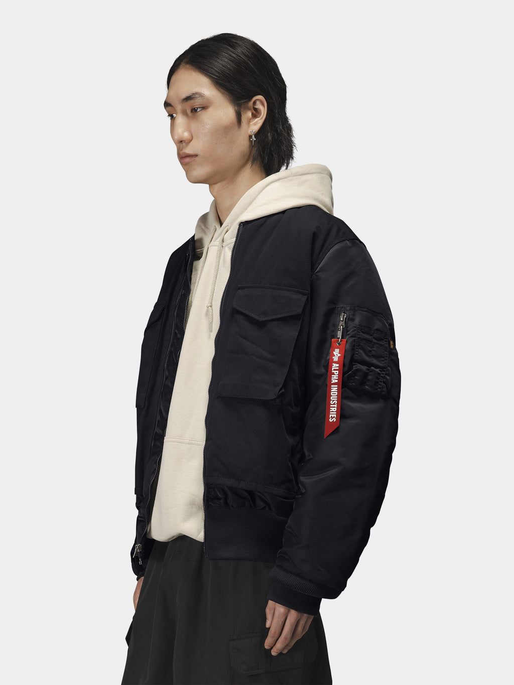 Alpha Industries MA-1 Mixed Cotton Flight Jacket in black over a beige hoodie; mixed cotton material and classic design features.