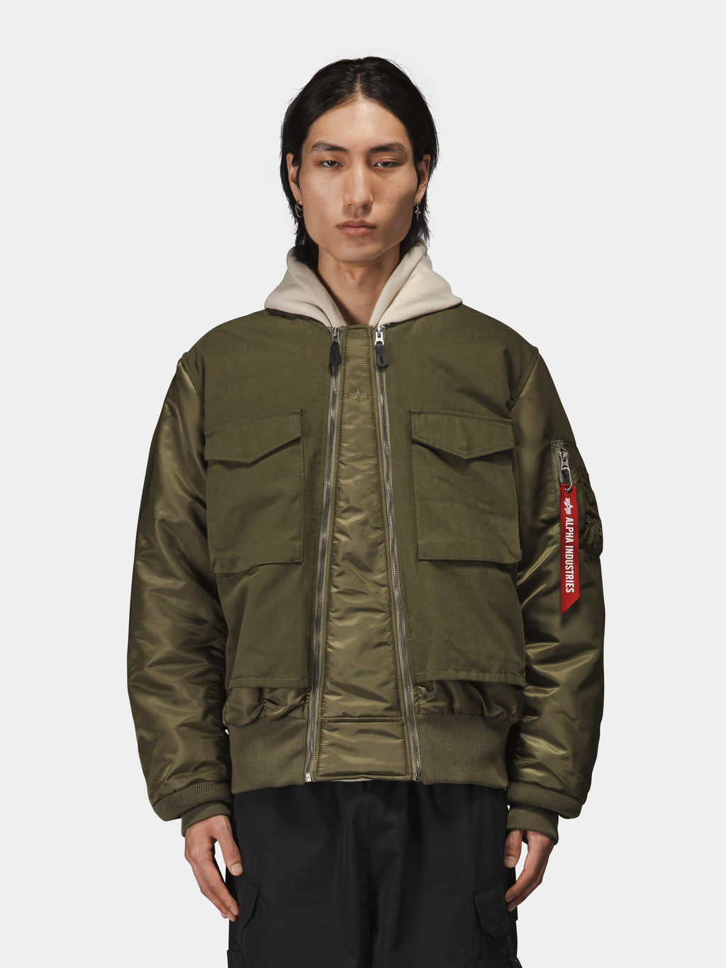 Alpha Industries MA-1 Mixed Cotton Flight Jacket in olive green with large front pockets and a beige hood.