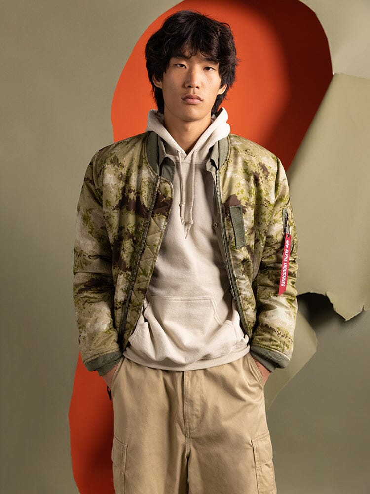 Alpha Industries MA-1 Mod Bomber Jacket, olive green, nylon material, ribbed cuffs and hem, front zipper closure.