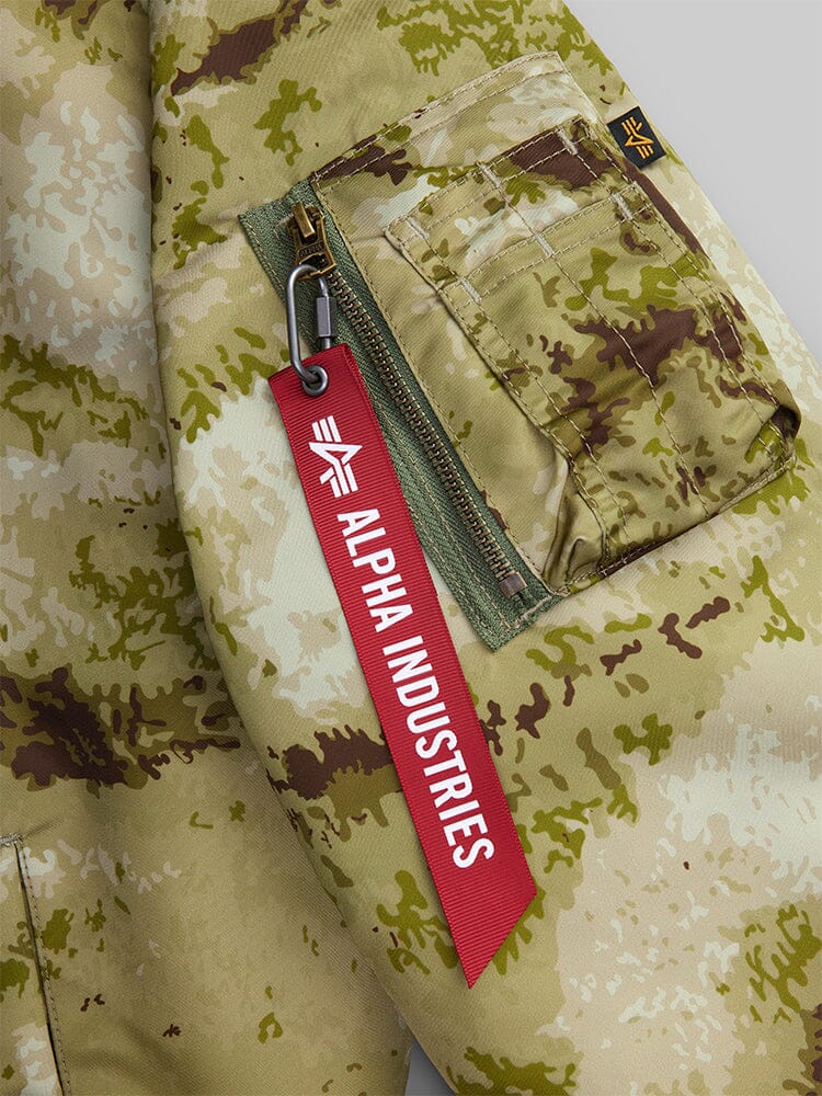 MA-1 Mod Bomber Jacket by Alpha Industries, camouflage sleeve, zippered pocket, red Alpha Industries tag.