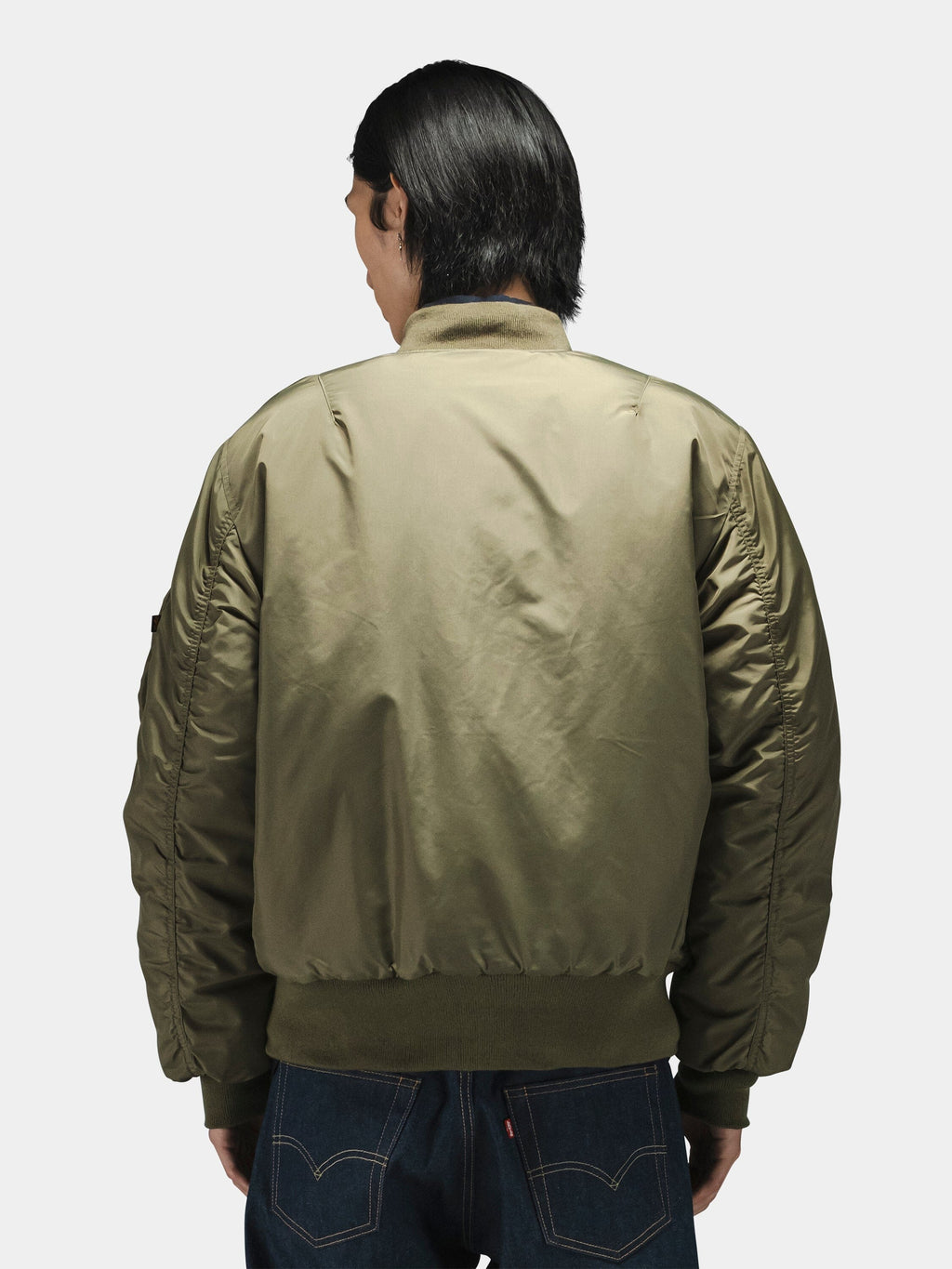 Alpha Industries MA-1 Oxford Flight Jacket in olive green with blue jeans.