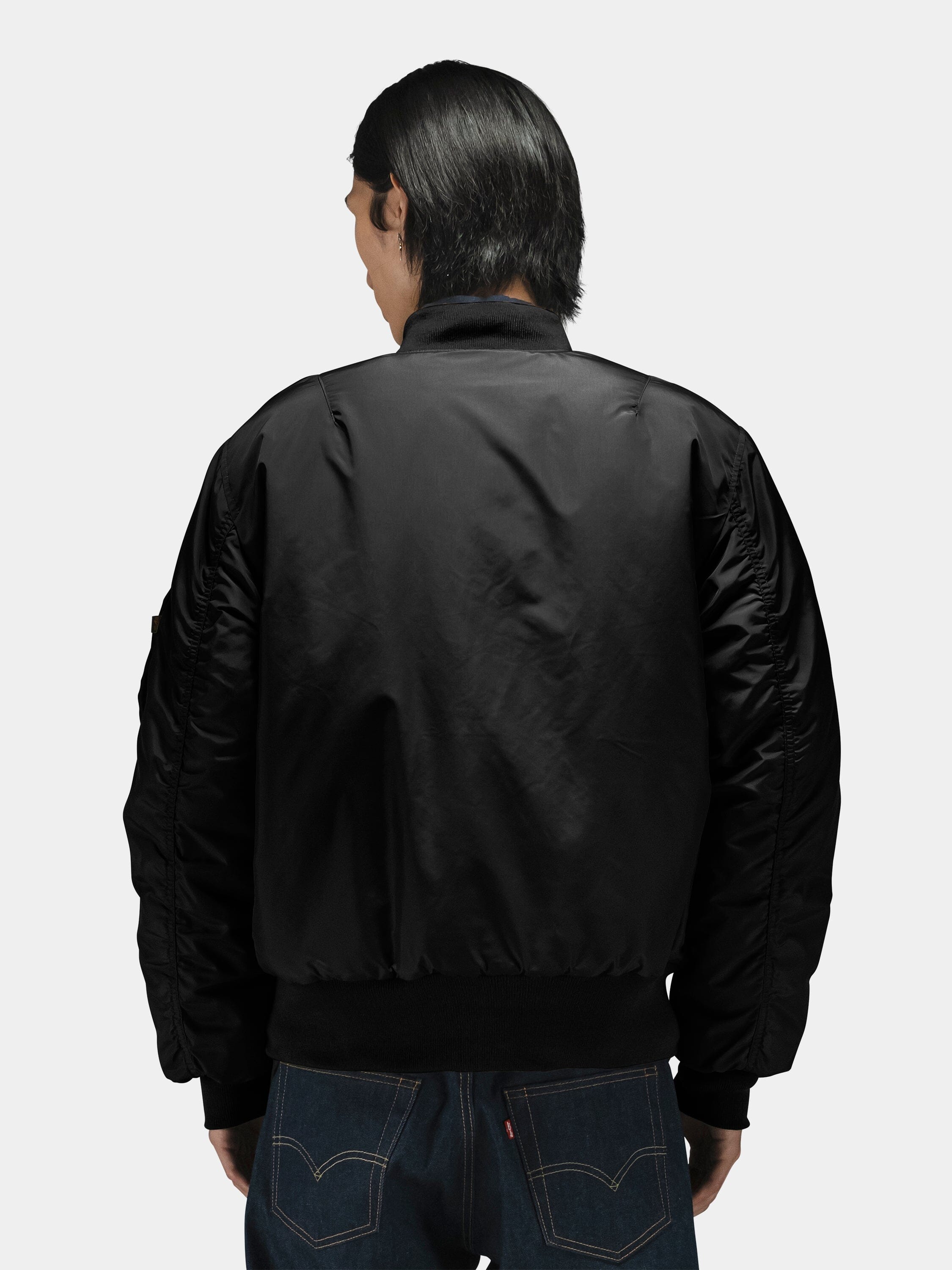 Alpha Industries MA-1 Oxford Flight Jacket with blue jeans; dark color, bomber style, ribbed cuffs, zip closure.
