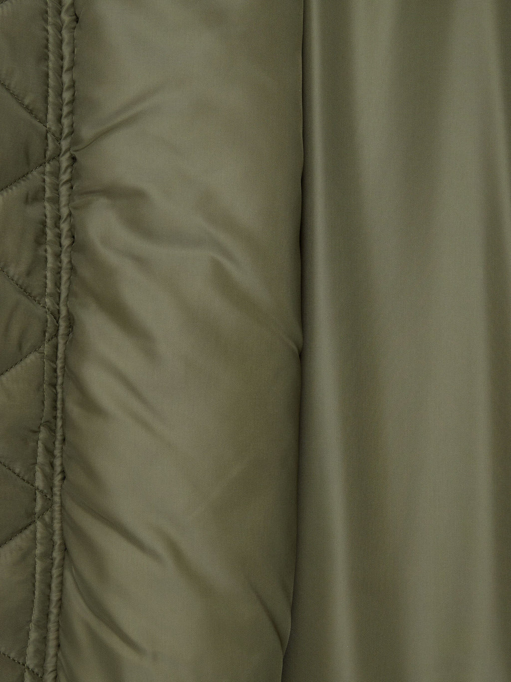 Olive green quilted fabric and smooth, slightly shiny surface of the Alpha Industries MA-1 Oxford Flight Jacket.
