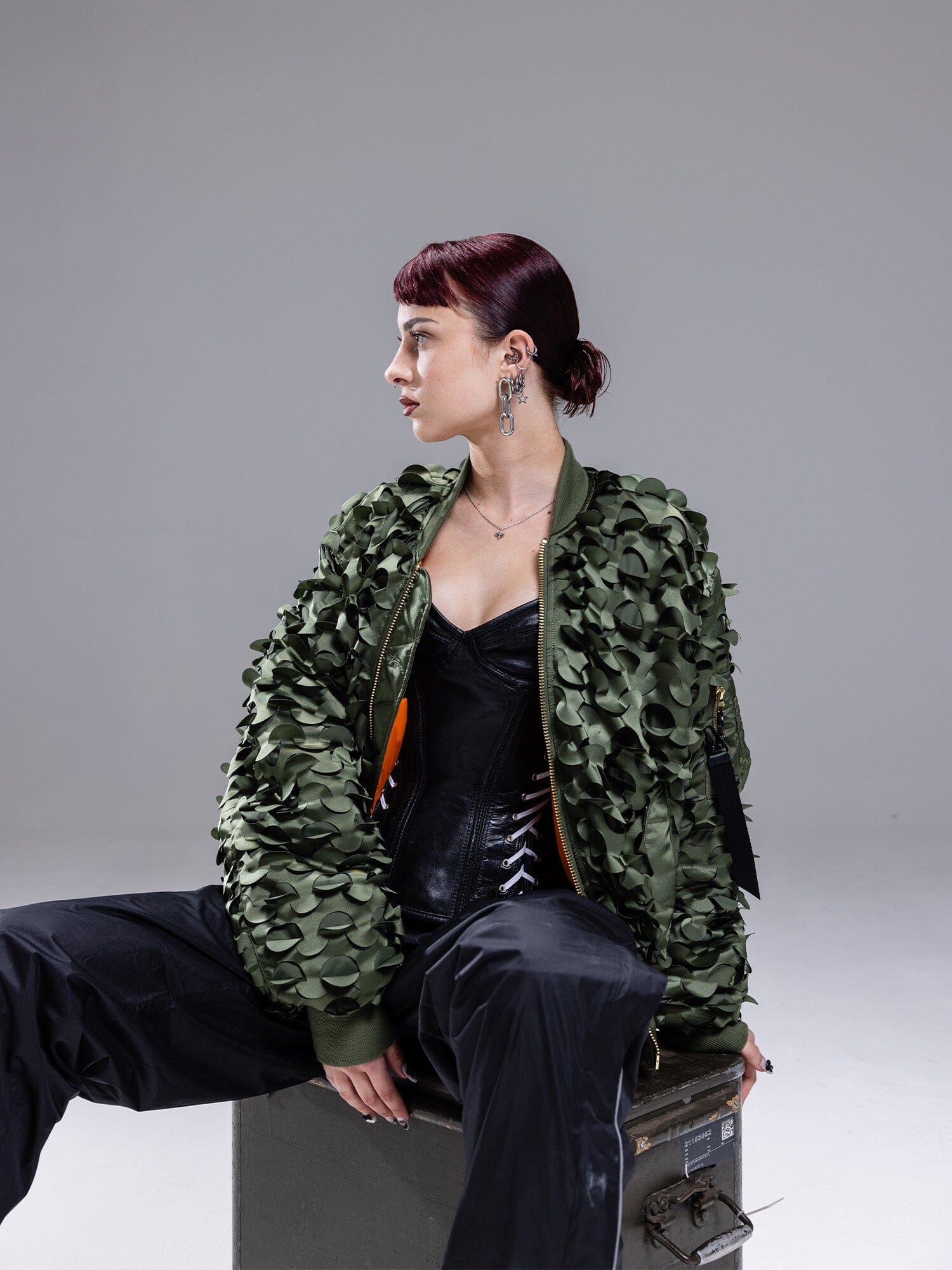 Alpha Industries MA-1 ULCANS Flight Jacket in textured green, black outfit visible under jacket.
