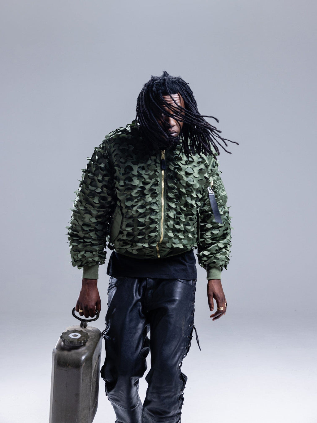 Alpha Industries MA-1 ULCANS Flight Jacket in textured green with black pants.
