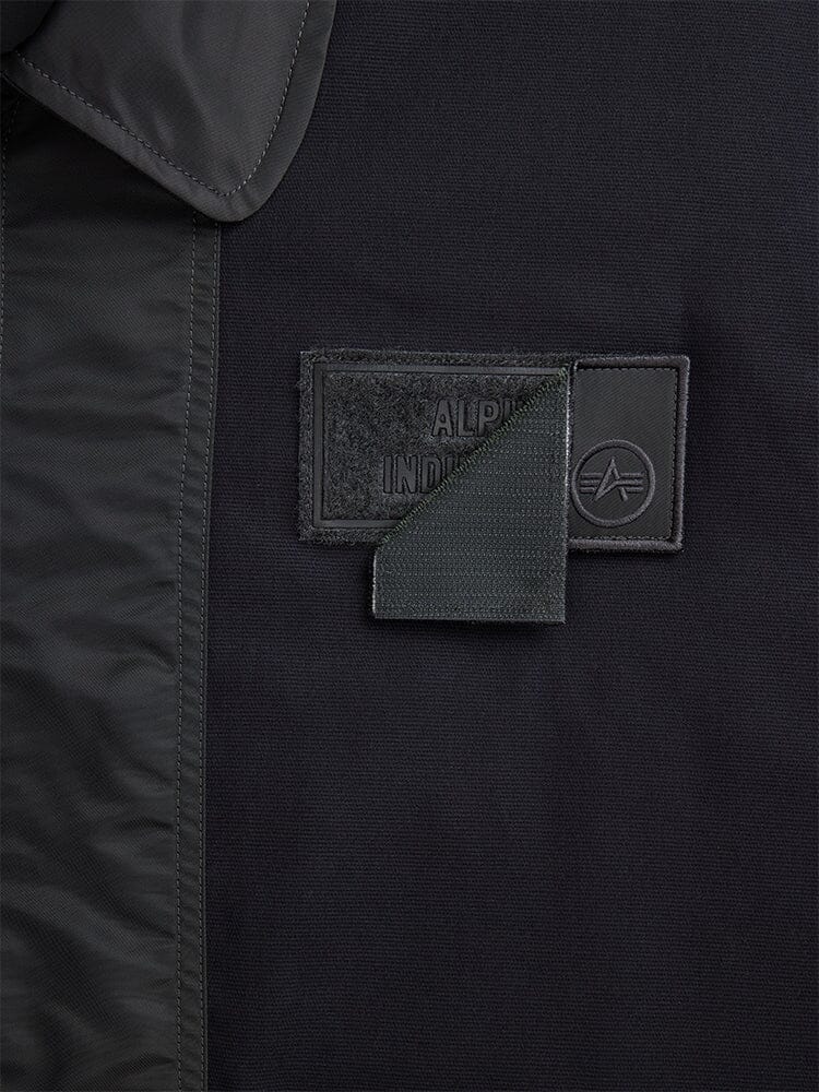 Alpha Industries Mixed Media CWU 36P Mod Jacket, black, rectangular patch with lifted corner revealing hidden detail.