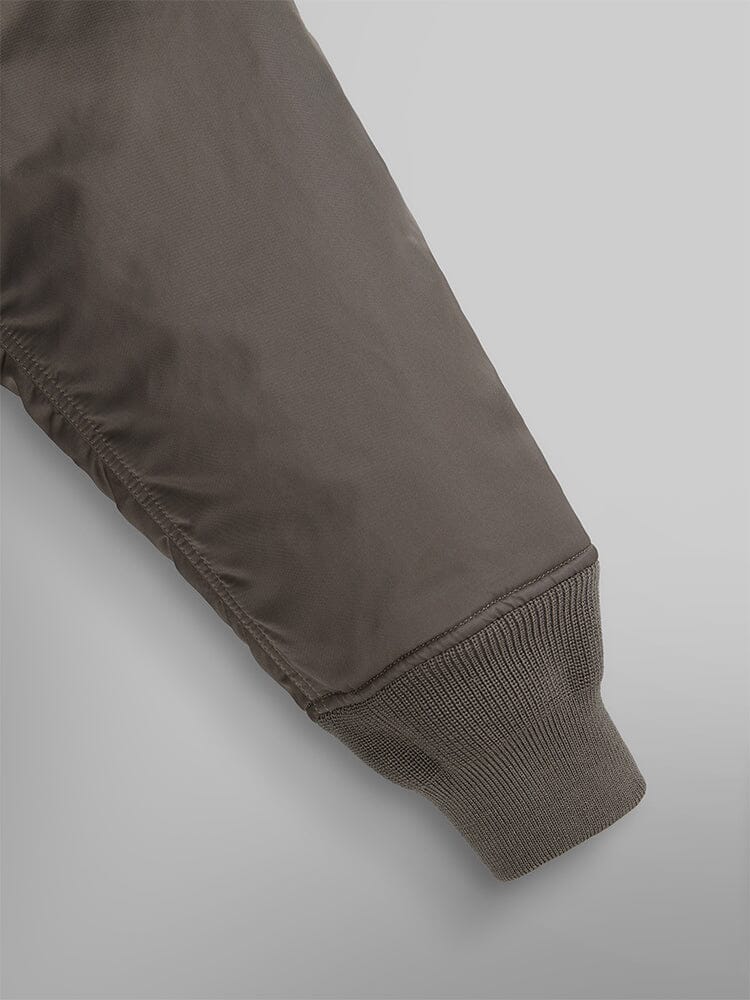 Close-up of a sleeve from the Alpha Industries Mixed Media Quilted Utility Jacket, featuring ribbed cuffs in coyote brown.