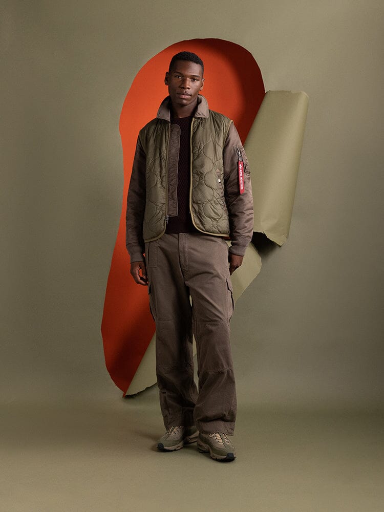 A man sporting the Mixed Media Quilted Utility Jacket in coyote brown by Alpha Industries.