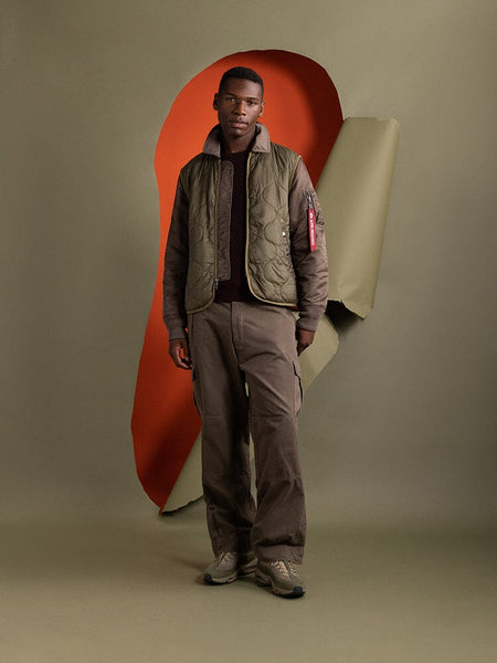 A man sporting the Mixed Media Quilted Utility Jacket in coyote brown by Alpha Industries.