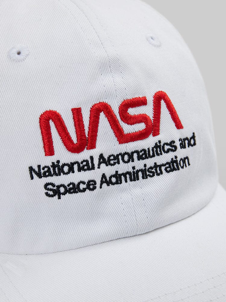Close-up of the NASAa Worm Logo Cap by Alpha Industries. This white cap showcases the NASA worm logo, with "National Aeronautics and Space Administration" embroidered in red and black.
