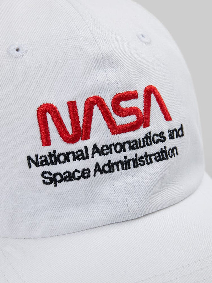 Close-up of the NASAa Worm Logo Cap by Alpha Industries. This white cap showcases the NASA worm logo, with "National Aeronautics and Space Administration" embroidered in red and black.