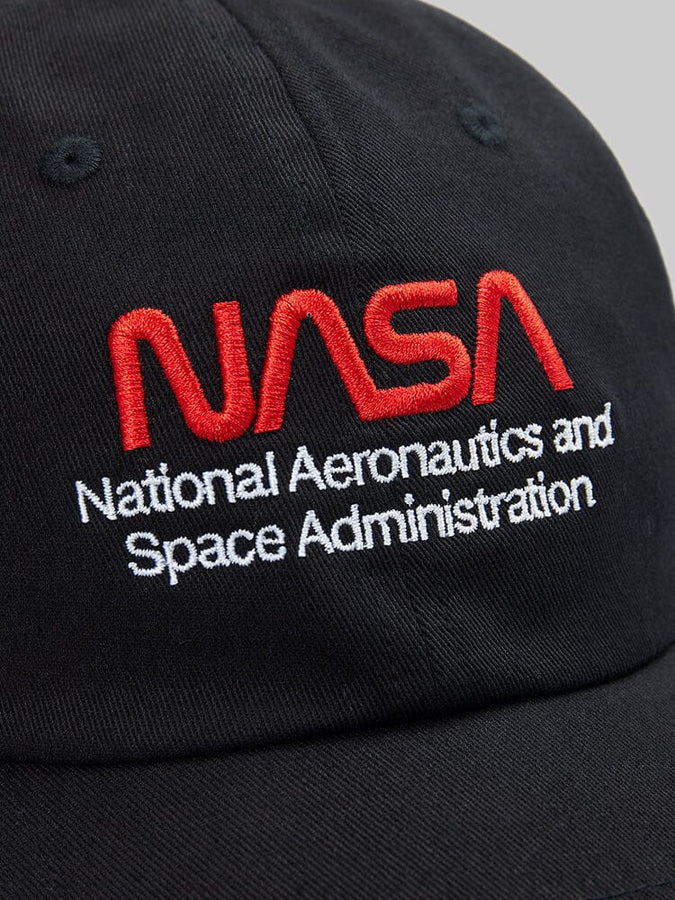 Close-up of the NASA Worm Logo Cap by Alpha Industries, showcasing the iconic red NASA worm logo with "National Aeronautics and Space Administration" embroidered in white.