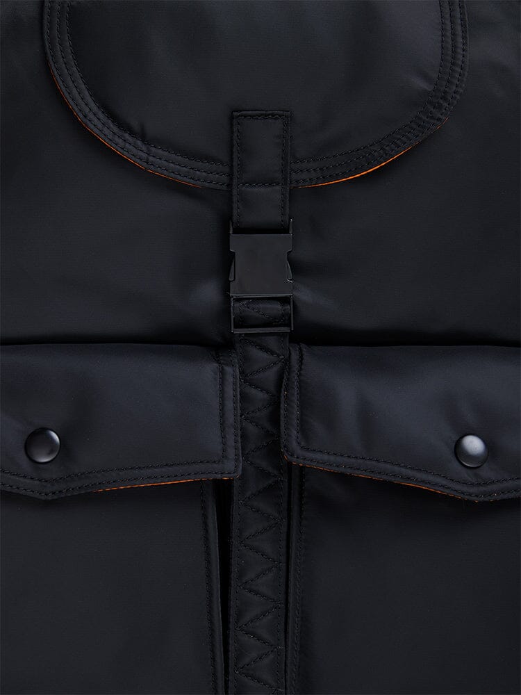 Alpha Industries Nylon Backpack in black nylon with plastic buckle closure, two snap button pockets, orange stitching details, and inner laptop sleeve.