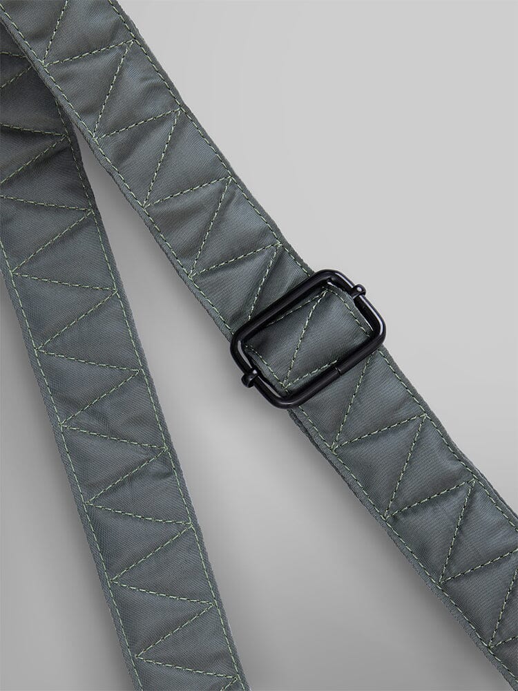 Close-up of the durable nylon strap from the Alpha Industries Nylon Messenger Bag, featuring an adjustable black buckle and visible stitching.