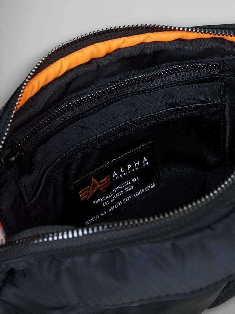 The Nylon Messenger Bag From Alpha Industries showcases a black exterior with an orange interior, multiple zippered compartments, and a durable nylon construction.
