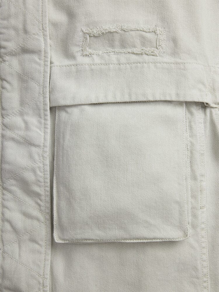 Alpha Industries Oversized Ctn Utility Jacket W in beige cotton canvas with rectangular cargo pocket and stitched label above it.