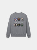 Alpha Industries Patched Crewneck in Medium Charcoal Heather, cotton-poly blend, with Alpha Industries text and seven embroidered back patches.