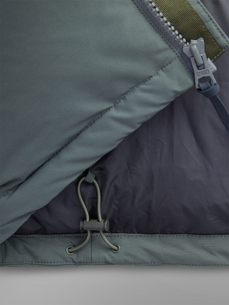 Alpha Industries Puffer Parka in green with water resistance, partially open zipper, and adjustable elastic cord with plastic toggle.