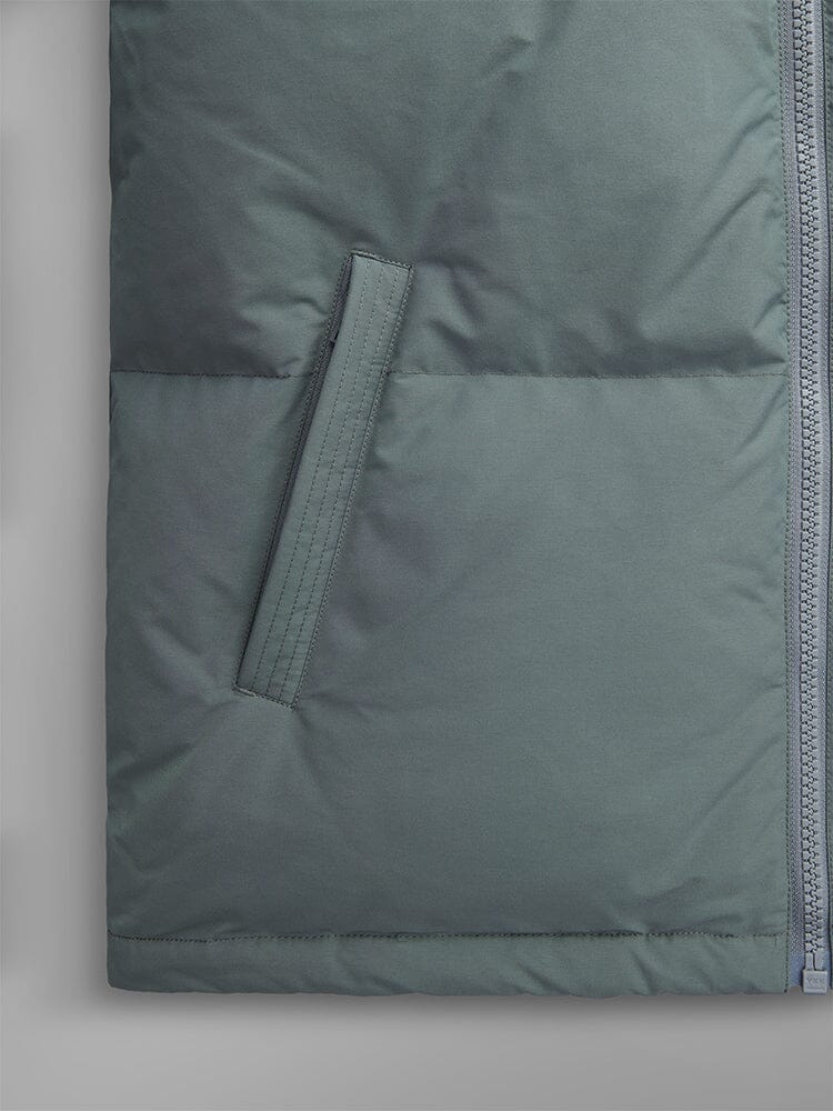 Alpha Industries Puffer Parka in muted green with side pocket, horizontal stitching, and zipper closure.