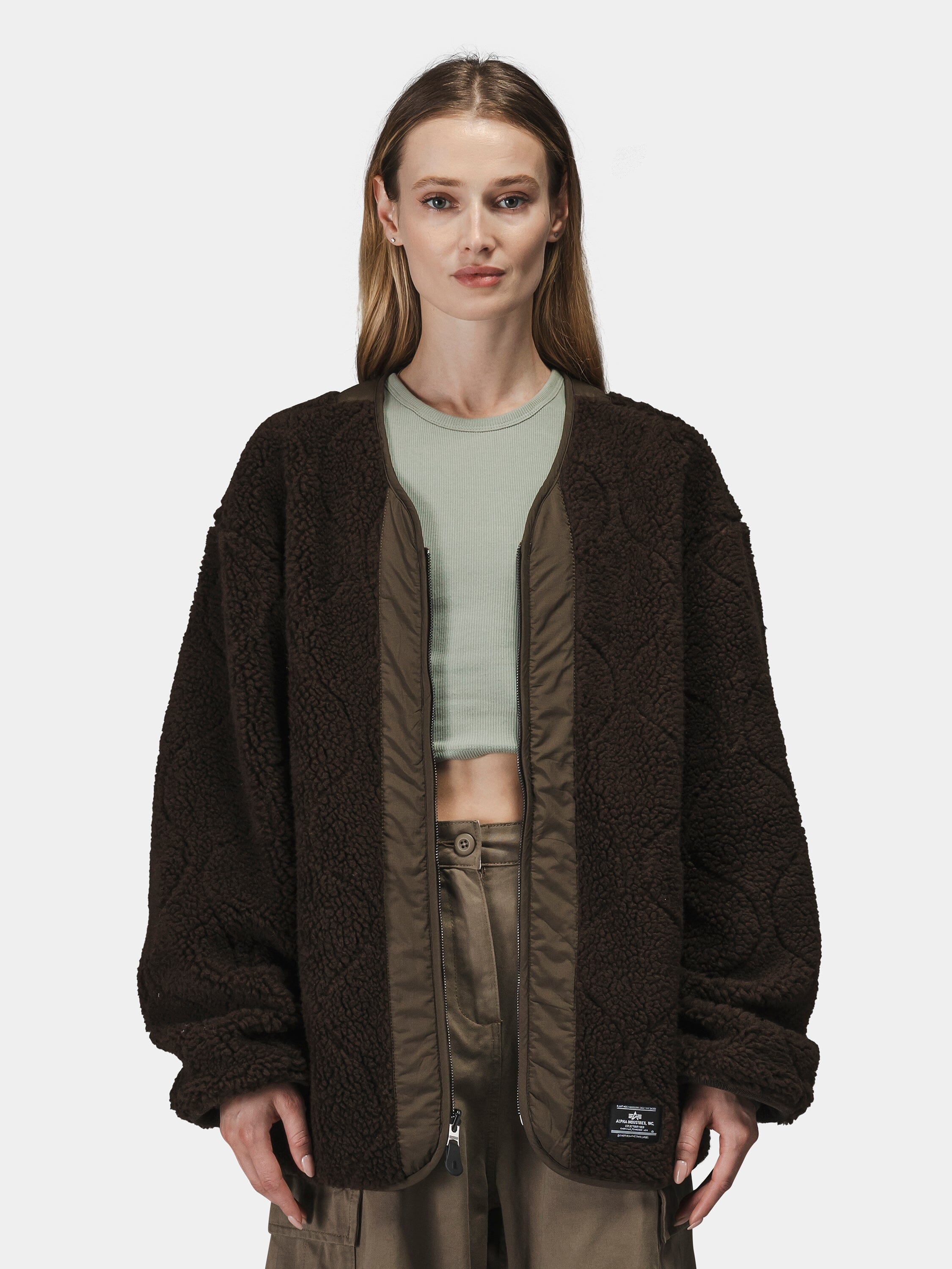 Alpha Industries Reversible M-65 Quilted Liner in dark brown with light green crop top and khaki pants.