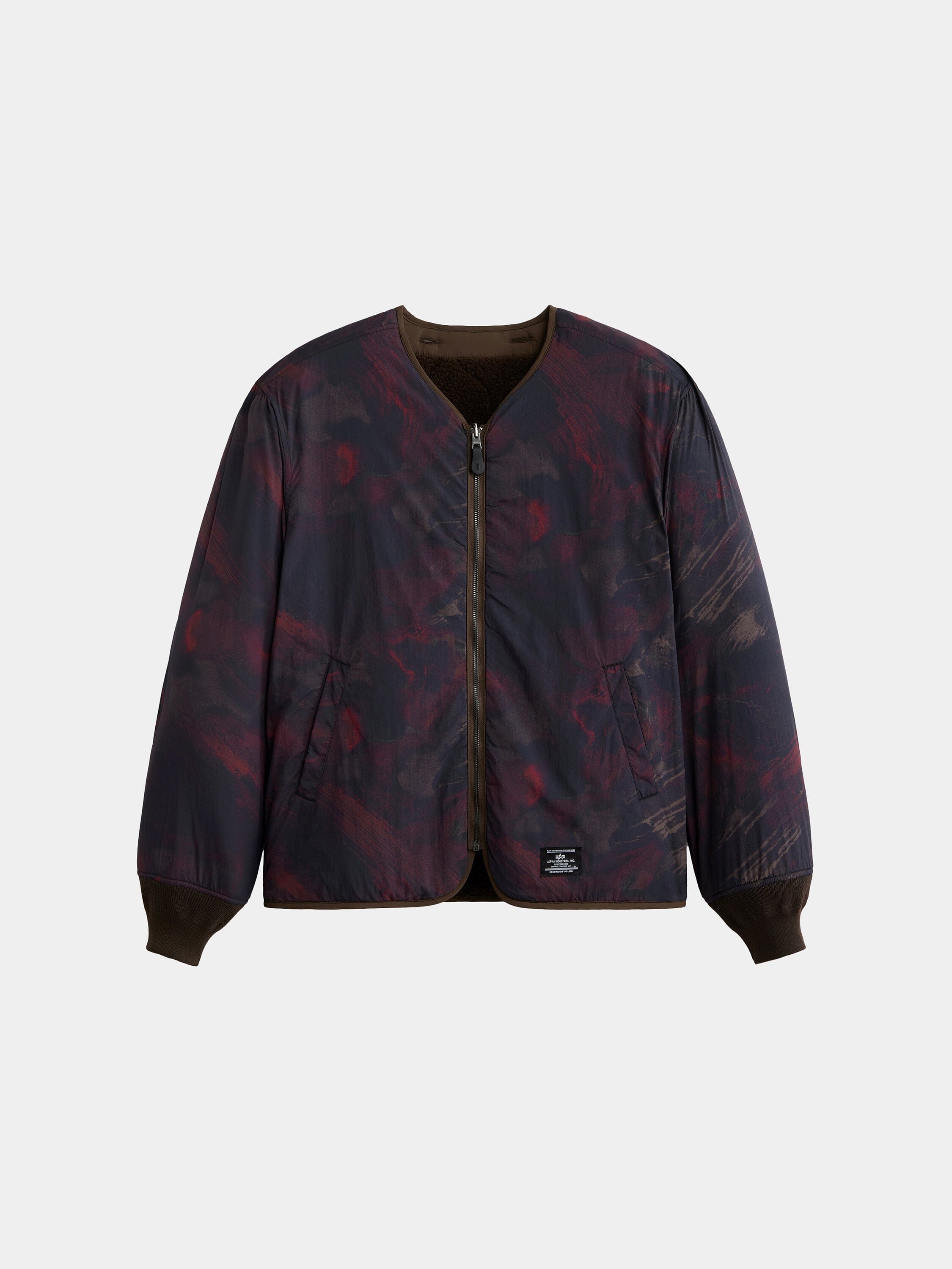 The Alpha Industries Reversible M-65 Quilted Liner, dark patterned bomber jacket with front zipper, side pockets, ribbed cuffs and collar.