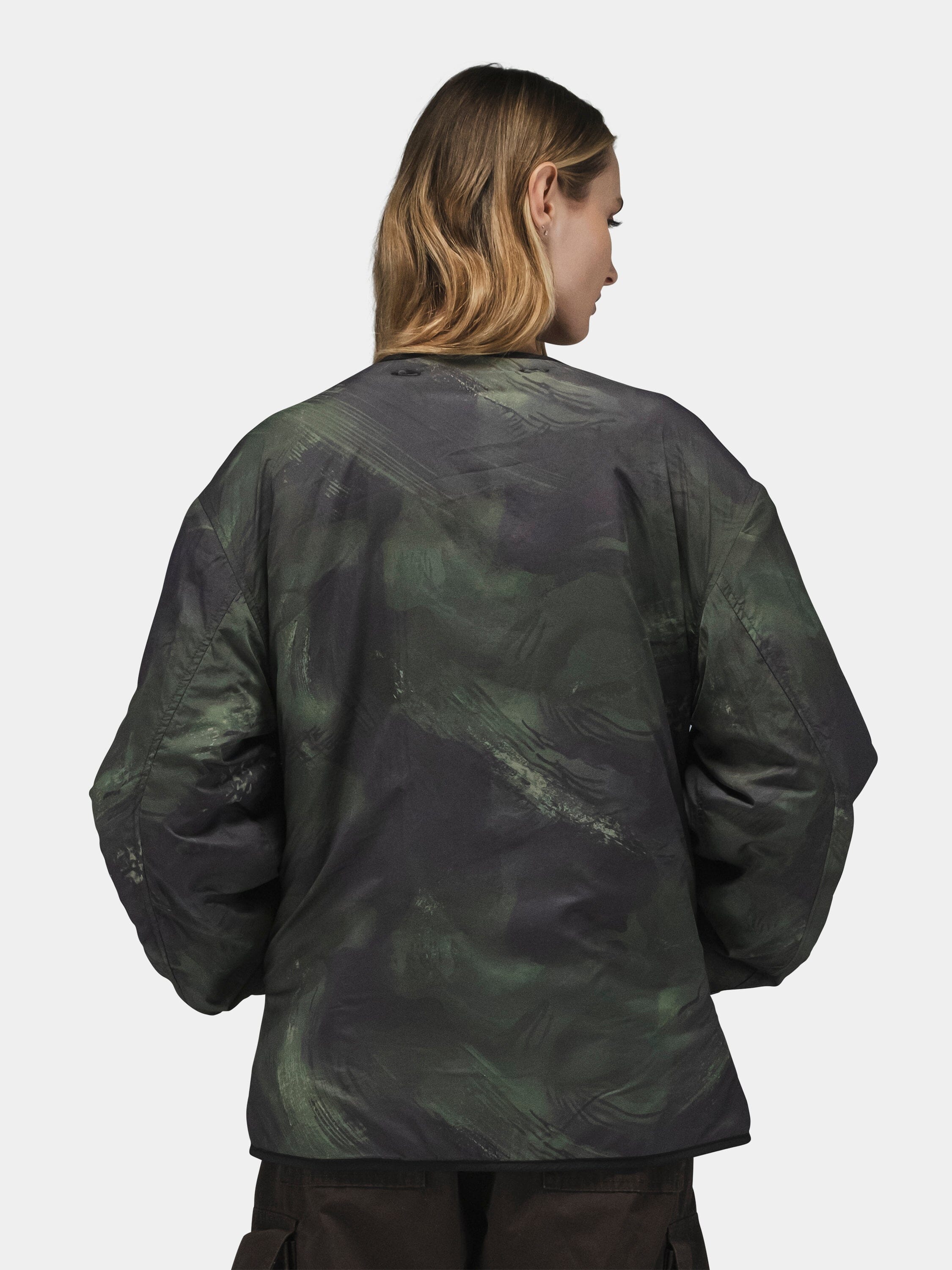 Alpha Industries Reversible M-65 Quilted Liner in dark green camo with brown pants.