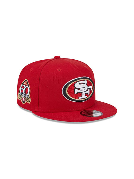 Introducing the San Francisco 49ers X Alpha X New Era 950 Cap, a collaboration from Alpha Industries and New Era featuring a vibrant red design. This snapback cap proudly displays the iconic San Francisco 49ers team logo on the front, along with a special patch commemorating their 60th season on the side.