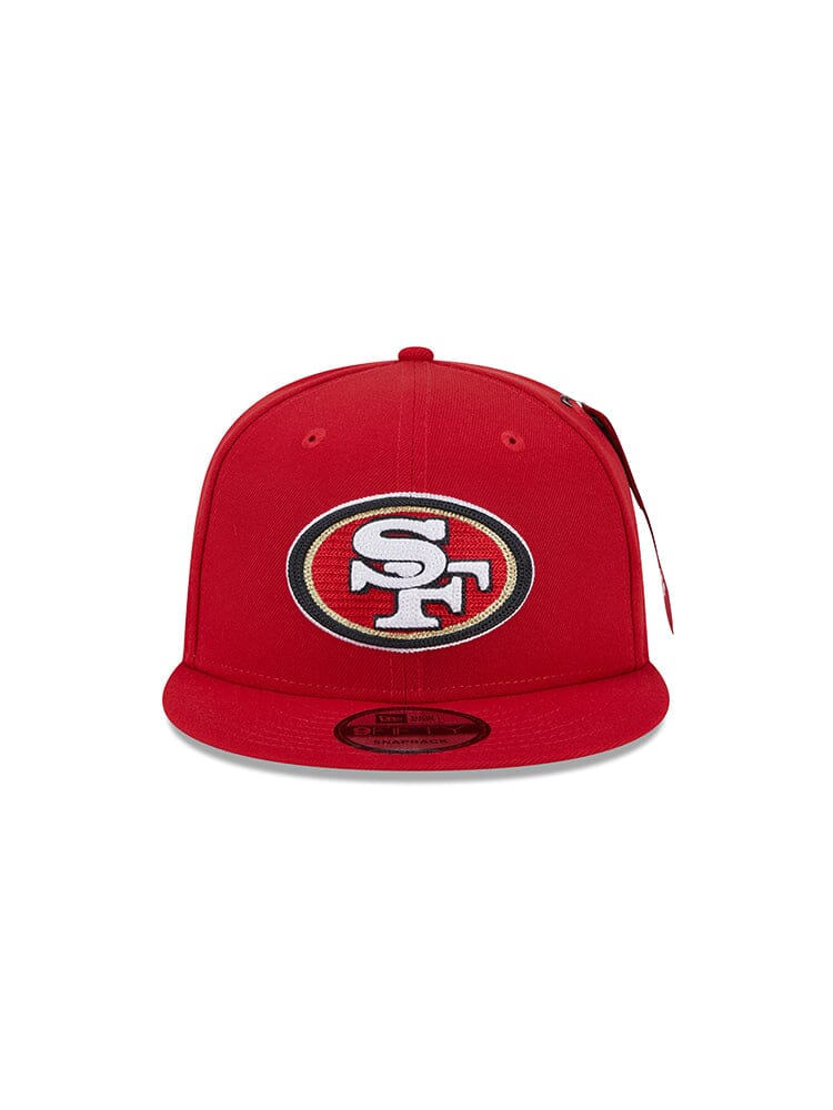 Red New Era 950 Cap from Alpha Industries, adorned with the renowned San Francisco 49ers team logo on the front.