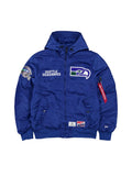 The Seattle Seahawks x Alpha Industries x New Era L-2B Bomber Jacket by Alpha Industries, in Pacific Blue, showcases team logos on the front, sleeve, and shoulder. This ripstop jacket includes pockets, a hood, and features a distinctive red zipper pull tag.