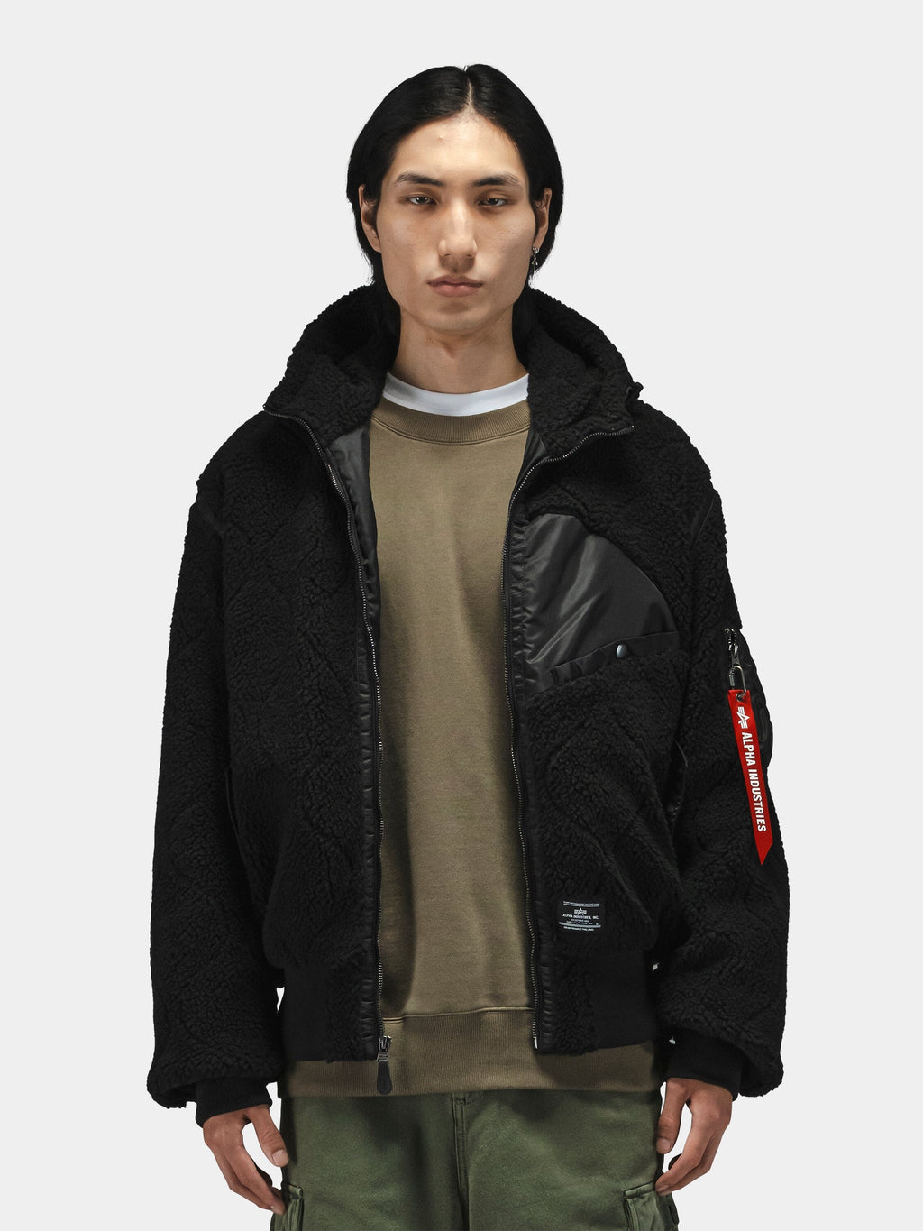 Alpha Industries Sherpa Onion Quilting Flight Jacket in black with brown shirt and green pants, featuring quilted design.
