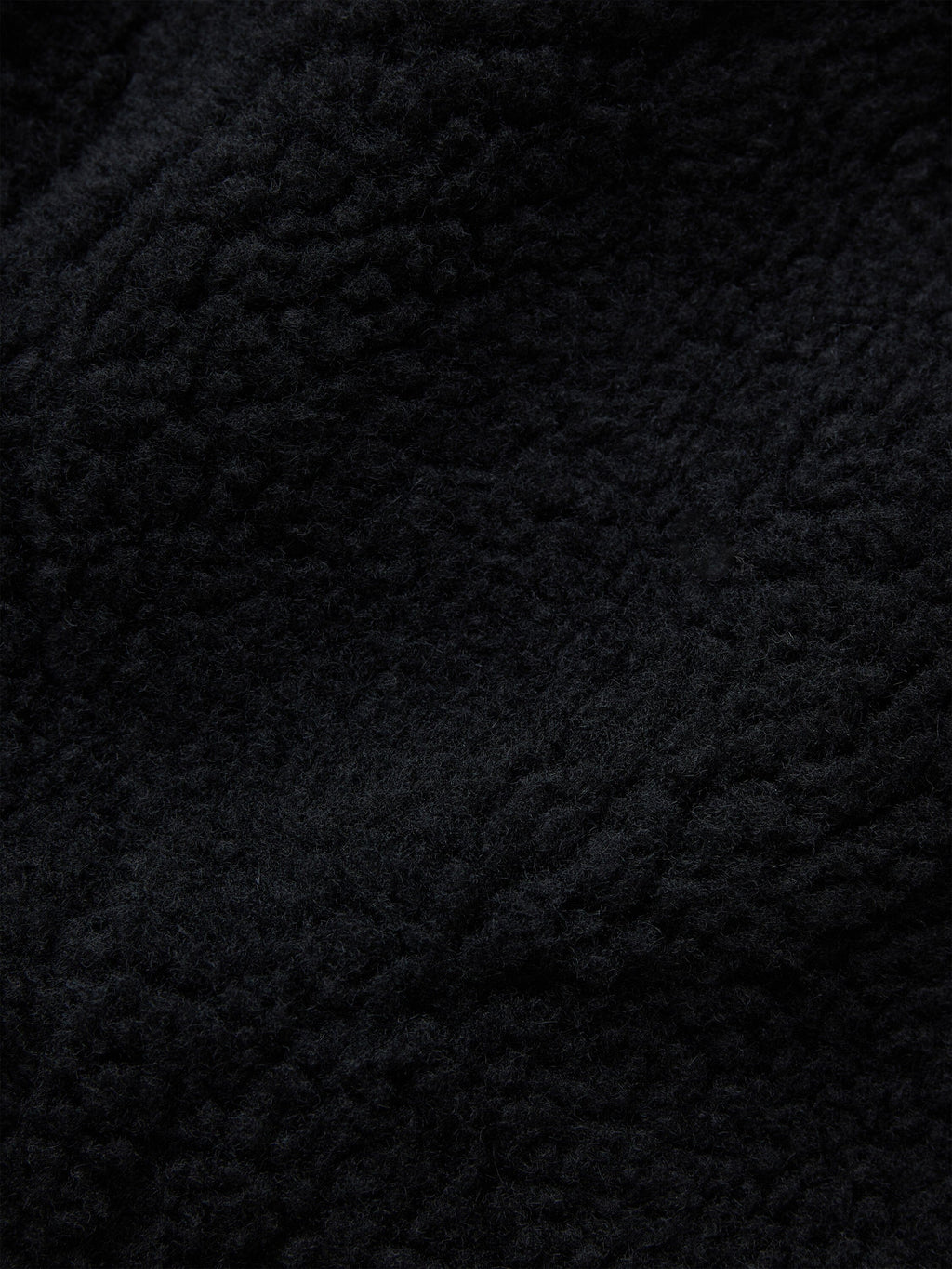 Alpha Industries Sherpa Onion Quilting Flight Jacket, black textured fleece fabric with irregular patterns.