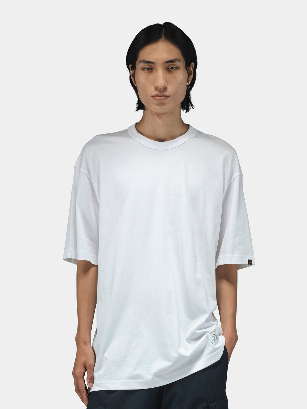 Alpha Industries Short Sleeve Relaxed Tee in dark color, paired with dark pants.