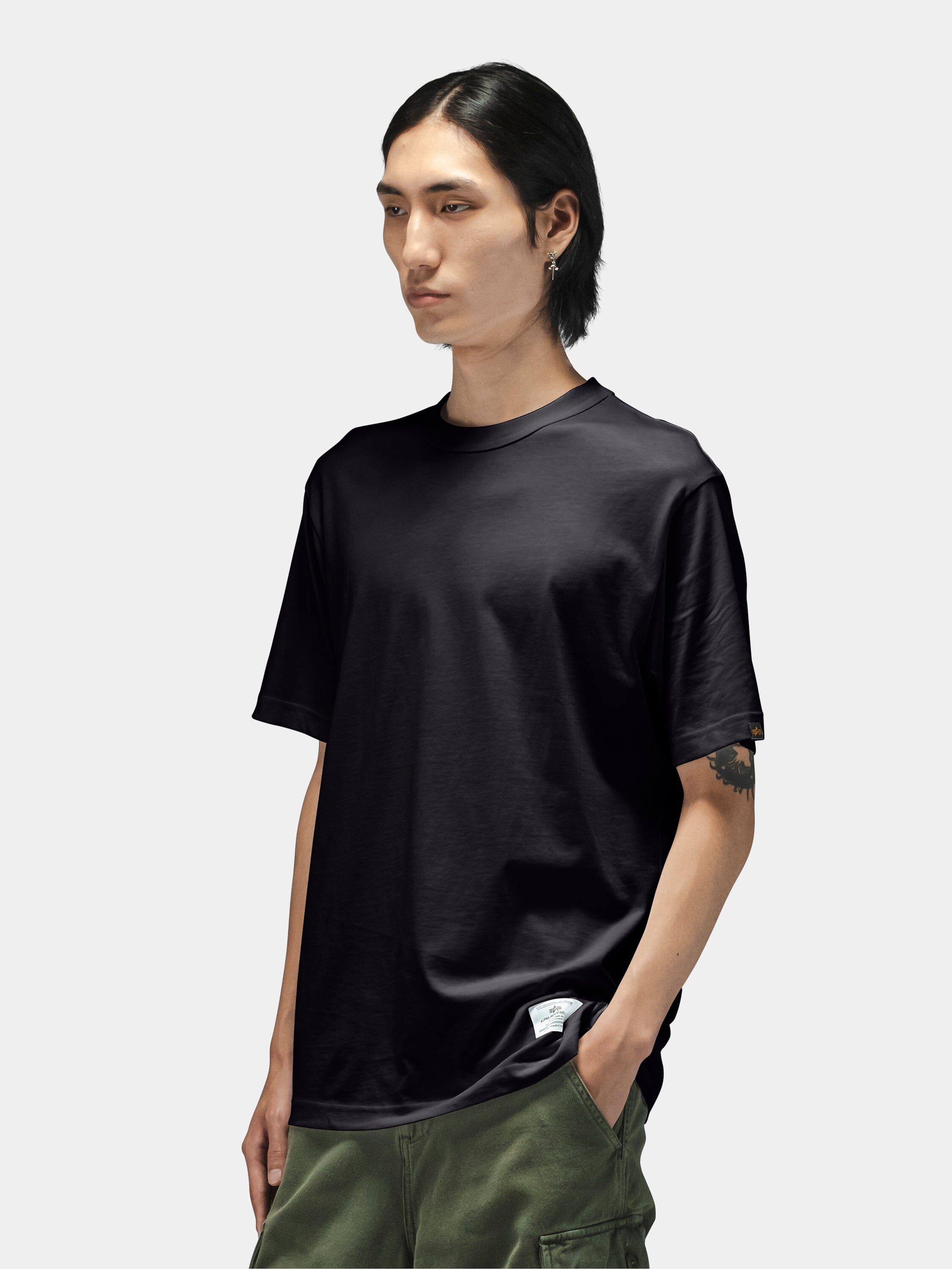 Alpha Industries Short Sleeve Regular Tee in dark color, paired with green pants.