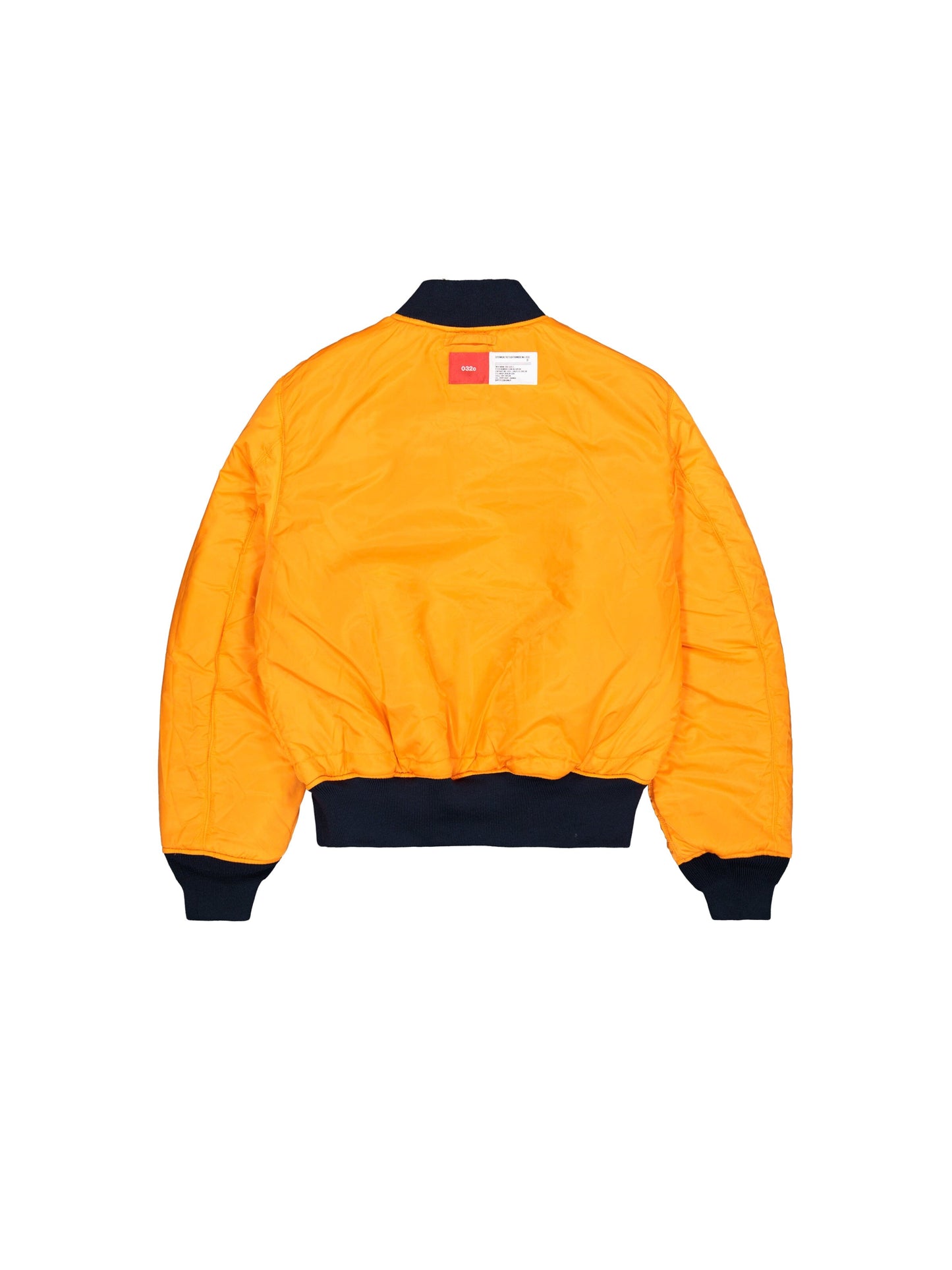 Alpha X 032c Flight Bomber by Alpha Industries in bright orange flight nylon with black cuffs, collar, and waistband, featuring a white and red label near the collar.